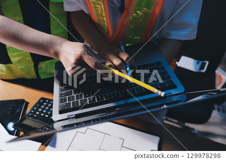 Closeup of team of industrial engineers meeting analyze machinery blueprints consult project on table in manufacturing factory. Working in manufacturing plant or production plant. Closeup of team of industrial engineers meeting analyze machinery blueprints consult project on table in manufacturing factory. Working in manufacturing plant or production plant. 129978298