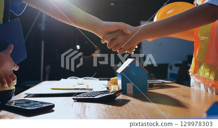 Closeup of team of industrial engineers meeting analyze machinery blueprints consult project on table in manufacturing factory. Working in manufacturing plant or production plant. 129978303