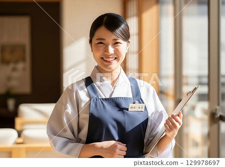 旅館裡一位面帶微笑的女工作人員歡迎客人 129978697