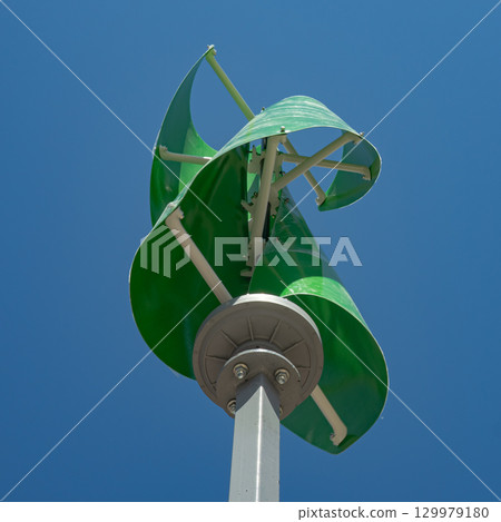 Wind turbine with green blades against a blue sky, green energy Wind turbine with green blades against a blue sky, green energy 129979180