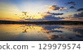 Scenic view of beautiful sunset or sunrise above the pond or lake at spring or early summer evening 129979574