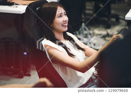 Young woman enjoying a racing game 129979688