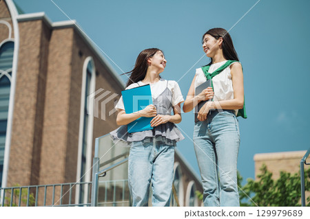 一位女大學生在校園散步,和朋友開心地聊天 一位女大學生在校園散步,和朋友開心地聊天 129979689
