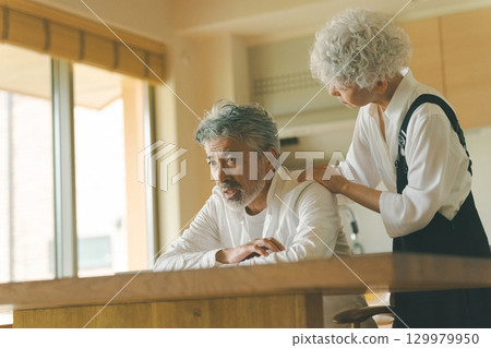A wife listens to her senior husband's complaints and comforts him 129979950