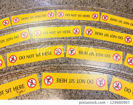 Do not sit here signage on the floor in a public space 129980907