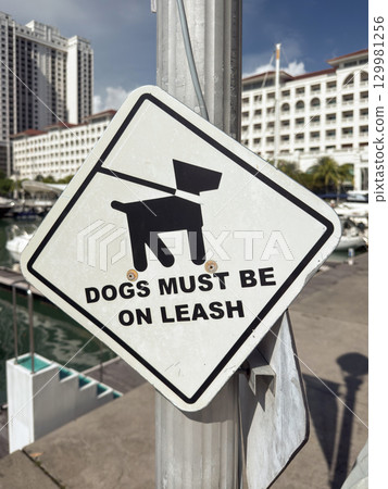 Dogs must be on leash sign near marina in Penang, Malaysia promotes responsible pet ownership 129981256