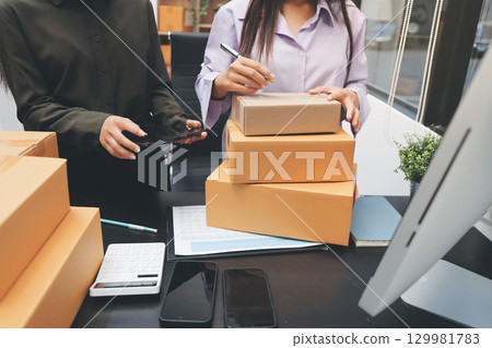 Portrait of Starting small businesses SME owners, two Asian woman check online orders Selling products working with boxs freelance work at home office, sme business online small medium enterprise 129981783