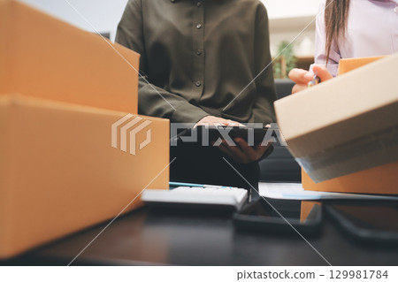 Portrait of Starting small businesses SME owners, two Asian woman check online orders Selling products working with boxs freelance work at home office, sme business online small medium enterprise Portrait of Starting small businesses SME owners, two Asian woman check online orders Selling products working with boxs freelance work at home office, sme business online small medium enterprise 129981784