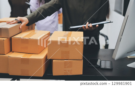 Portrait of Starting small businesses SME owners, two Asian woman check online orders Selling products working with boxs freelance work at home office, sme business online small medium enterprise Portrait of Starting small businesses SME owners, two Asian woman check online orders Selling products working with boxs freelance work at home office, sme business online small medium enterprise 129981901