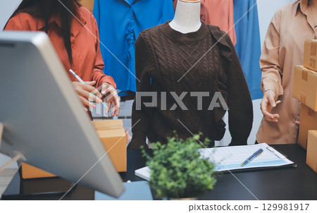 Portrait of Starting small businesses SME owners, two Asian woman check online orders Selling products working with boxs freelance work at home office, sme business online small medium enterprise 129981917