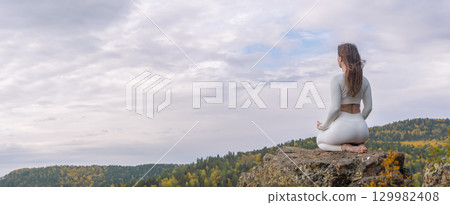 Woman in white clothes meditates on mountain during autumn, embracing nature and inner peace with a stunning view copy space panorama Woman in white clothes meditates on mountain during autumn, embracing nature and inner peace with a stunning view copy space panorama 129982408