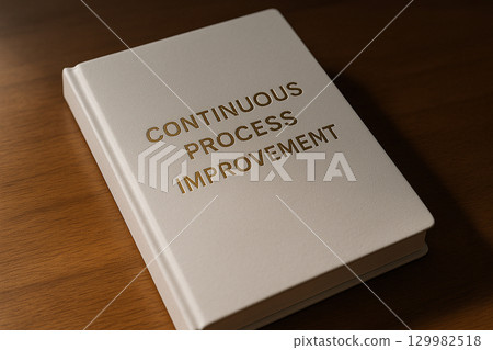 Continuous Process Improvement words printed on another brown notebook lying on office desk 129982518