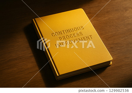 Continuous Process Improvement text on closed yellow notebook resting on wooden surface Continuous Process Improvement text on closed yellow notebook resting on wooden surface 129982536