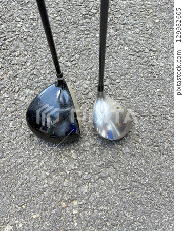 Golf Clubs Resting on Asphalt Show Differences in Design and Wear 129982605