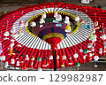 Lacquerware wind chimes hanging from a red Japanese umbrella 129982987