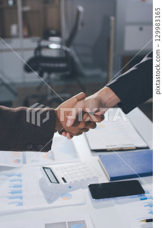 Two businessmen shaking hands after reaching agreement in office Two businessmen shaking hands after reaching agreement in office 129983165