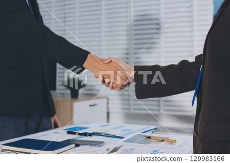 Two businessmen shaking hands after reaching agreement in office Two businessmen shaking hands after reaching agreement in office 129983166