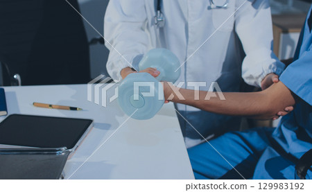 Person using hand weight with support of nurse 129983192