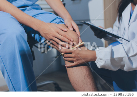 Physical therapist teaching a patient how to do exercises for his knee pain Physical therapist teaching a patient how to do exercises for his knee pain 129983196