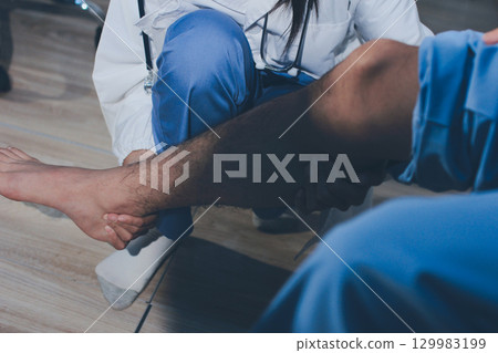 Physical therapist teaching a patient how to do exercises for his knee pain Physical therapist teaching a patient how to do exercises for his knee pain 129983199