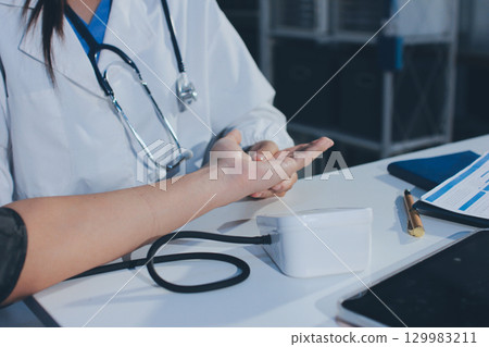 Doctor checking patient arterial blood pressure in hospital. Health care Concept Doctor checking patient arterial blood pressure in hospital. Health care Concept 129983211