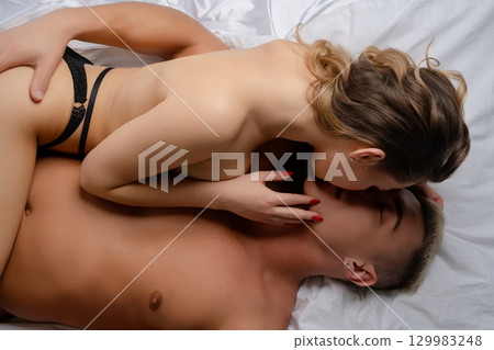 Couple sharing an intimate moment in bed while embracing with love and affection Couple sharing an intimate moment in bed while embracing with love and affection 129983248