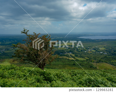 Overlooking scenic Irish landscape near Gap of Dunloe, County Kerry, Ireland, view shows distant lake under cloudy sky. Overlooking scenic Irish landscape near Gap of Dunloe, County Kerry, Ireland, view shows distant lake under cloudy sky. 129983281