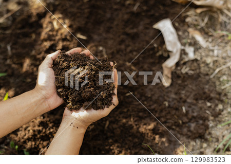 Scooping up compost, a gift from nature, with both hands - an image of a mindful lifestyle Scooping up compost, a gift from nature, with both hands - an image of a mindful lifestyle 129983523