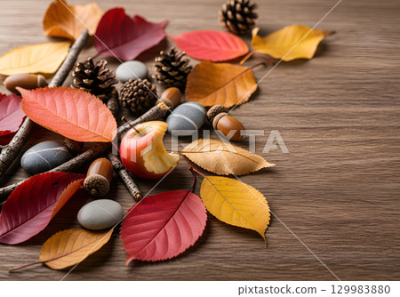 A natural autumn composition of leaves, cones and apples on a tree. A natural autumn composition of leaves, cones and apples on a tree. 129983880