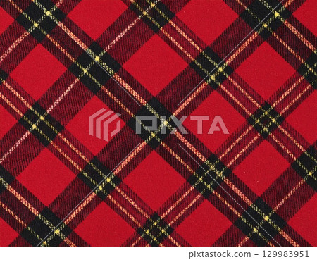 A traditional Scottish tartan check with a red base and black and yellow lines. 129983951
