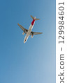 A twin-engine passenger plane descends before landing at an airport. 129984601