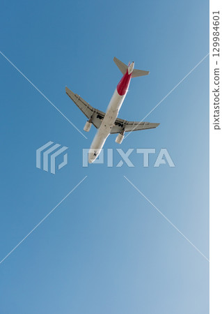 A twin-engine passenger plane descends before landing at an airport. 129984601
