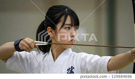 練習射箭的女孩表情嚴肅地瞄準目標 129984696