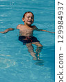 A young boy is swimming in a pool 129984937
