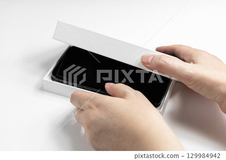 Closeup of female hands holding phone box 129984942