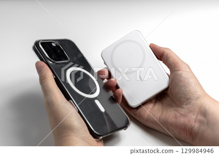 Closeup of hand holding phone and powerbank Closeup of hand holding phone and powerbank 129984946