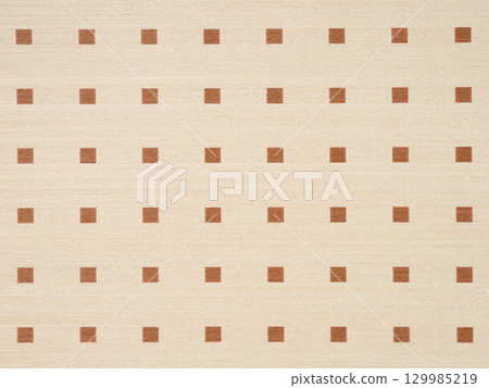 Warm beige veneer surface with a regular pattern of brown squares 129985219