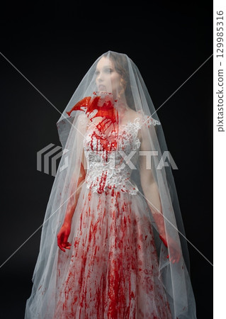 Woman in wedding dress covered in blood holds katana in dark setting Woman in wedding dress covered in blood holds katana in dark setting 129985316