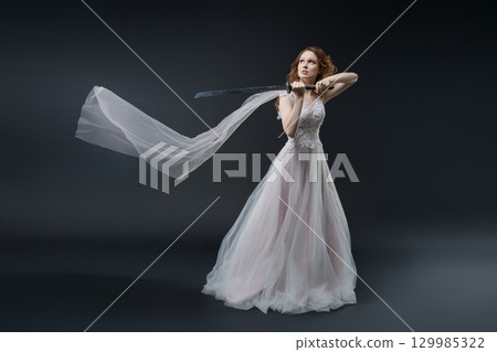 Elegant bride in lingerie-style gown, poised for a regal portrait 129985322