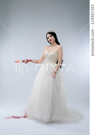 Bride in white lingerie with knife in a haunting display of beauty and danger Bride in white lingerie with knife in a haunting display of beauty and danger 129985383