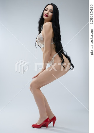 Elegant bride in lingerie poses gracefully, embodying beauty and charm 129985436