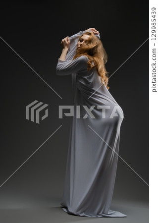 Sensual elegance of a woman in lingerie against a dark background 129985439