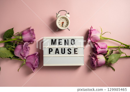Word Menopause on light box with pink roses and alarm clock, flat lay, pink background Word Menopause on light box with pink roses and alarm clock, flat lay, pink background 129985465