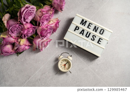 Word Menopause with pink roses and alarm clock, flat lay, grey background Word Menopause with pink roses and alarm clock, flat lay, grey background 129985467