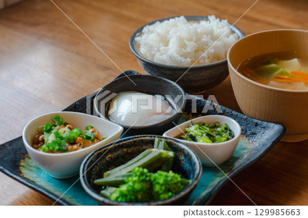 A Japanese-style breakfast of rice, miso soup, natto, a soft-boiled egg, and a small bowl of vegetables A Japanese-style breakfast of rice, miso soup, natto, a soft-boiled egg, and a small bowl of vegetables 129985663