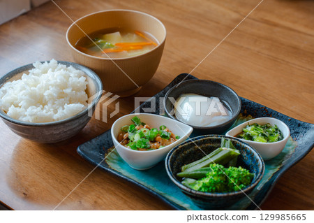 A Japanese-style breakfast of rice, miso soup, natto, a soft-boiled egg, and a small bowl of vegetables A Japanese-style breakfast of rice, miso soup, natto, a soft-boiled egg, and a small bowl of vegetables 129985665