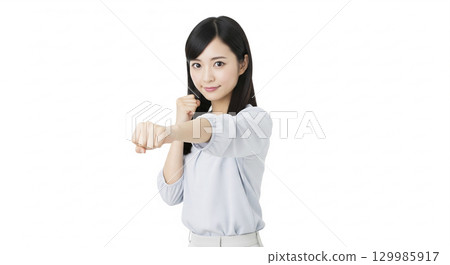 Businesswoman thrusting her fist (white background) 129985917