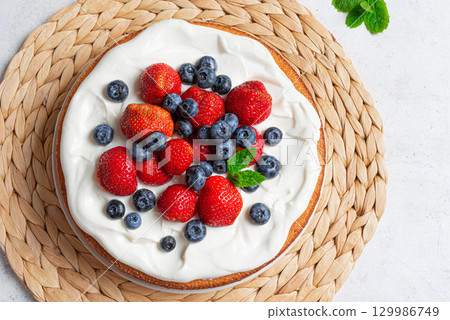 Sponge cake with whipped cream and fresh berries 129986749