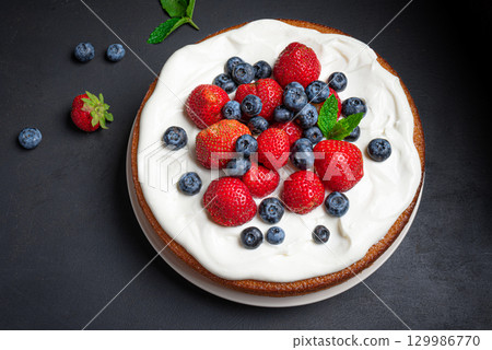 Sponge cake with cream cheese and fresh berries 129986770