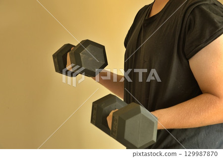 Man weigh training using dumb bells 129987870